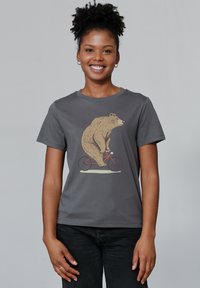 Grijze katoenen t-shirt met een afbeelding van een beer die op een rode fiets rijdt. Korte mouwen, ronde hals en zachte textuur.