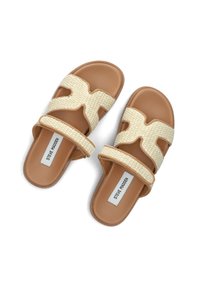 Beige geweven sandalen met een kruisbandontwerp en een gladde bruine zool. De banden hebben een gestructureerd patroon en een bedrukt logo op de binnenzool.