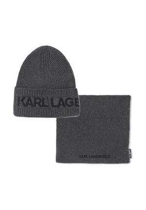 Bonnet en tricot gris et cache-cou assorti. Les deux présentent une texture côtelée et une bande logo sur le bonnet, tandis que le cache-cou a une surface lisse.
