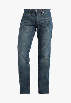 Granatowe dżinsy o prostym kroju nogawki. Cechy obejmują kieszenie z przodu, zamek błyskawiczny oraz kontrastowe pomarańczowe przeszycia.