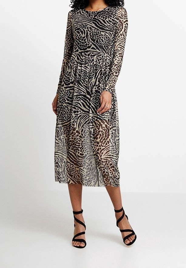 Genomskinlig klänning med långa ärmar som har ett leopardmönster i beige och svart, med en insydd midja och en svallande midi-längd. Svarta remsandaler.