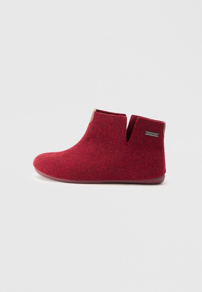 Red felt ankle boots with a smooth texture, rounded toe, and cut-out design. Light-colored accents at the heel and minimal branding detail.