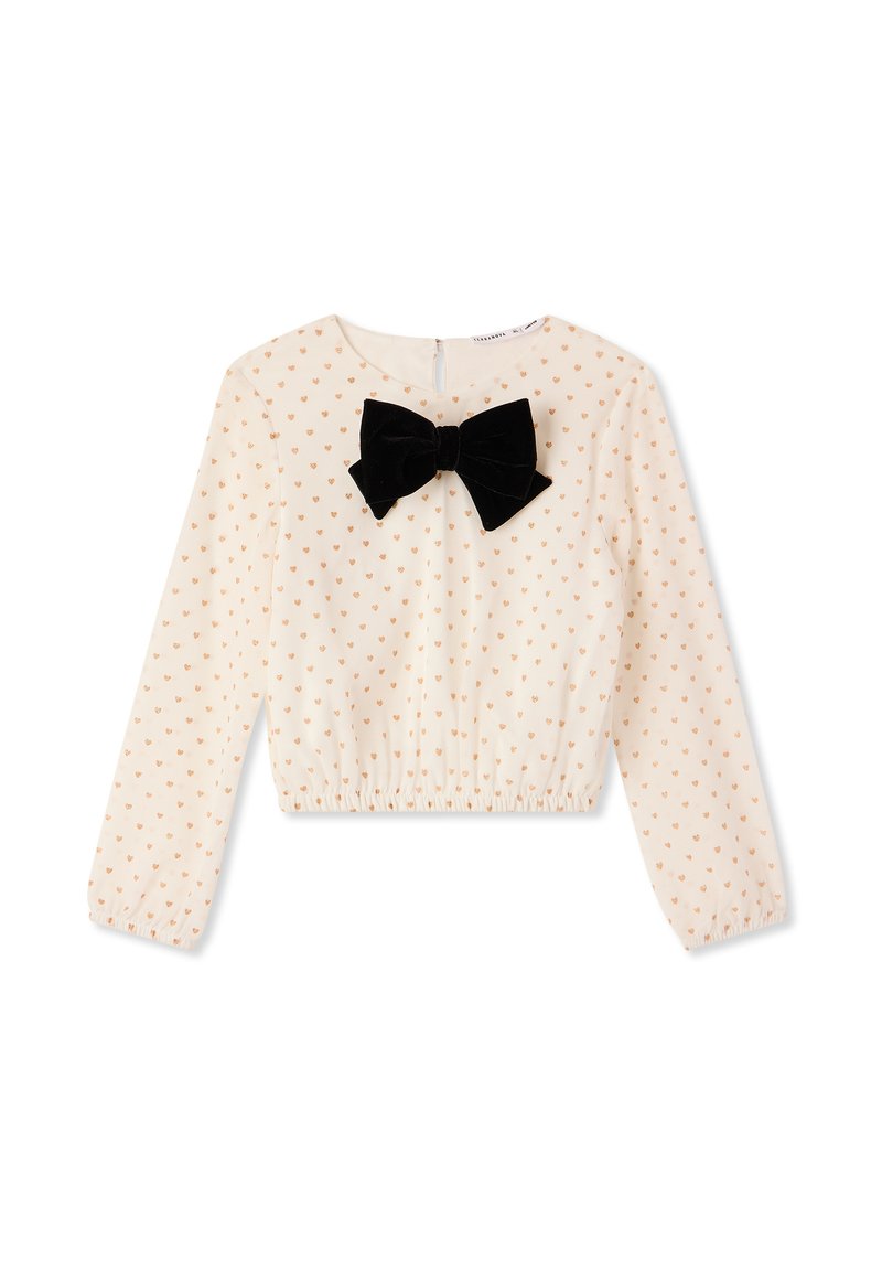 Top cropped in crema con maniche lunghe, caratterizzato da un fiocco in velluto nero e un piccolo motivo a cuori dorati, fondo elastico e chiusura con zip sul retro.