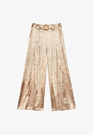 Pantalones de pierna ancha en color beige con un patrón texturizado, cuentan con una cintura alta y un hebilla circular. La tela tiene un aspecto suave y brillante.