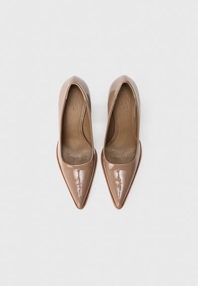Nude patent leather high-heeled shoes with pointed toes, smooth texture, and a brown leather insole. Classic pump design.