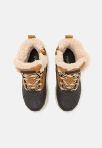 Bruine en zwarte enkelboots met een gestructureerde bovenkant, fleece voering en gemusterde veters. Voorzien van een rubberen zool en een lipje voor eenvoudig aan- en uittrekken.