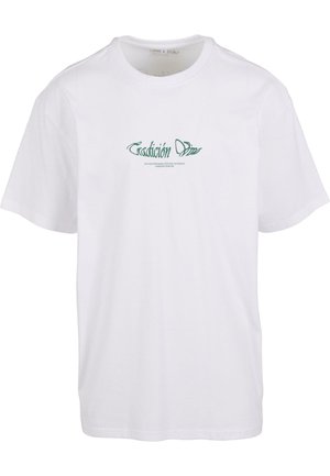 Fehér, rövidujjú pamut póló, zöld színű „Tradición Dim” felirattal a mellkasán, stilizált betűtípussal. Kerek nyakú fazon.