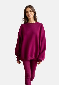 Fioletowy, oversize'owy sweatshirt, z mieszanki bawełny, okrągły dekolt, obniżone ramiona, ściągacze. W zestawie dopasowane spodnie. Gładka tekstura.