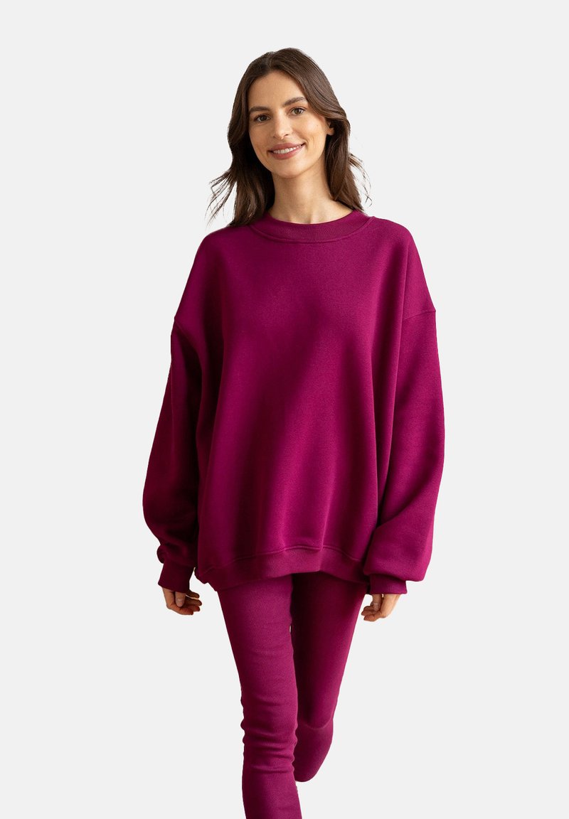 Fioletowy, oversize'owy sweatshirt, z mieszanki bawełny, okrągły dekolt, obniżone ramiona, ściągacze. W zestawie dopasowane spodnie. Gładka tekstura.