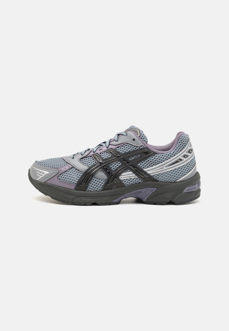 Chaussure de course avec tige en mesh gris et violet, bandes noires de la marque et semelle noire épaisse avec amorti visible au talon.