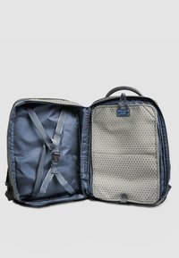 Zaino grigio con motivo geometrico all'interno, doppio scomparto, spallacci regolabili e manico superiore per un facile trasporto.