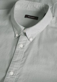 Lichtgroene overhemddoor met een gladde stof, voorzien van witte knopen, een klassieke button-down kraag en een discrete merklabel.