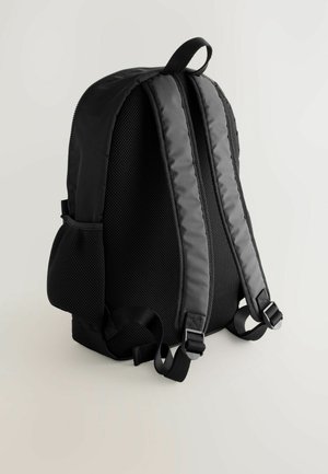 Juodas kuprinė su paminkštintu tinkliniu nugaros paviršiumi, dviem diržais, reguliuojamais sagtimis ir šoninėmis kišenėmis. Yra sklandus užtrauktukas ir patvari medžiaga.