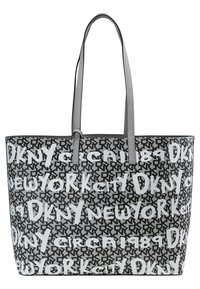 Sac cabas DKNY noir et blanc avec bandoulières, couvert de motifs répétitifs avec les textes « DKNY », « New York » et « Circa 1989 ».