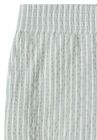 Light blue and white vertical striped textured fabric with a smocked elastic waistband, showing part of a garment.