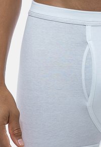 Boxer da uomo in cotone bianco con una texture a coste, dotati di un elastico a contrasto e di un'apertura frontale funzionale.
