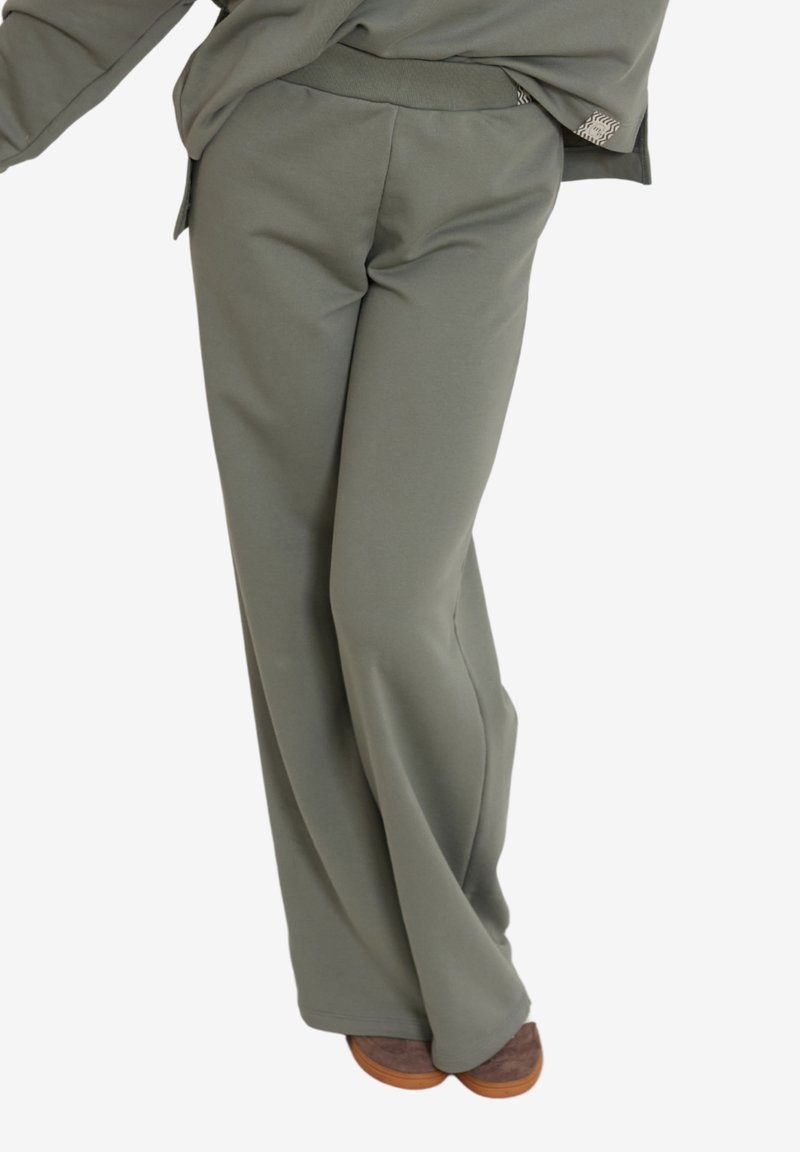 Lekkie, proste spodnie w kolorze oliwkowym, charakteryzujące się miękką teksturą, elastycznym pasem oraz minimalistycznym designem.