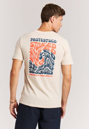 Beige katoenen t-shirt met een kleurrijke, draaiende afbeelding op de achterkant met de tekst "STOKED" in verschillende groottes en kleuren.