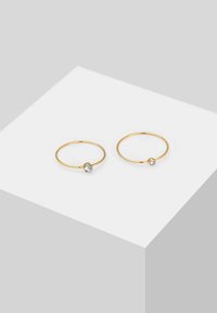 Goldene Creolen mit glatter Oberfläche, die jeweils einen klaren Edelsteinakzent aufweisen. Einfaches kreisförmiges Design, ohne zusätzliche Verzierungen.
