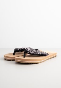 Zwart-witte luipaardprint flip-flops met een beige zool, voorzien van een zachte band en een grof rubberen buitenzool voor grip.