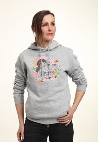 Felpa grigia con maniche lunghe, caratterizzata da una stampa grafica di una ragazza e un gatto circondati da accenti floreali in rosa e verde.