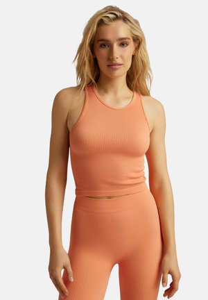 Prążkowany koralowy top na ramiączkach z wysokim dekoltem i bezrękawowym krojem, w połączeniu z pasującymi legginsami o wysokim stanie. Gładka tekstura i dopasowany fason.