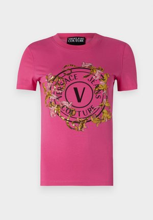 T-shirt di cotone rosa con un design a logo circolare caratterizzato da motivi floreali e serpenti, impreziosito da paillettes dorate e nere.