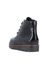 Bottine noire en cuir avec une finition brillante, bout rond et design à lacets. Semelle épaisse en caoutchouc noir avec un accent marron le long du bord.