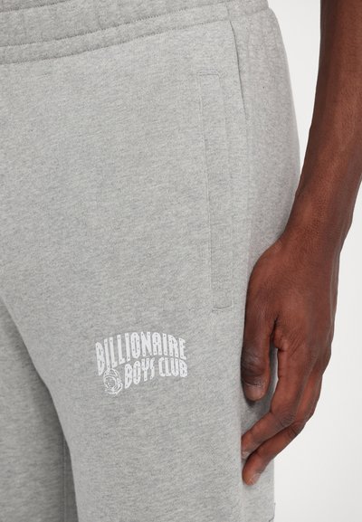 Grey sweatpants with a brushed texture, featuring side pockets and a white "Billionaire Boys Club" logo on the thigh. Elastic waistband detail.