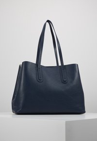 Granatowa skórzana torba na ramię z teksturowanym wykończeniem, dwiema długimi uchwytami i otwartym designem. Zaprojektowana z myślą o wszechstronności i trwałości.