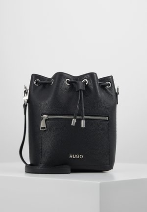 Sac seau en cuir noir avec cordon de serrage en haut, poche avant zippée, quincaillerie argentée et logo "HUGO" estampé à l'avant.