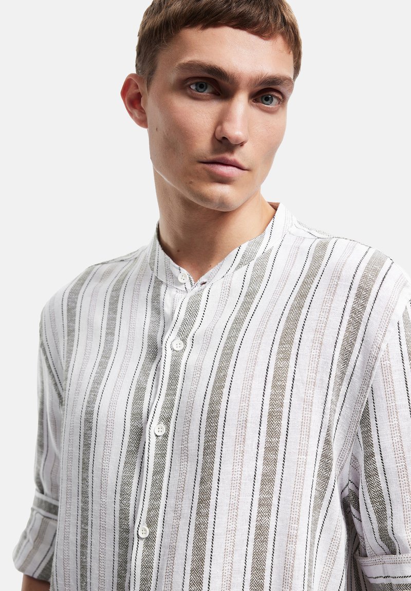 Witte gestreepte shirt met een bandkraag, knoopsluiting en textuur met dunne zwarte en grijze lijnen, met een visgraatpatroon.