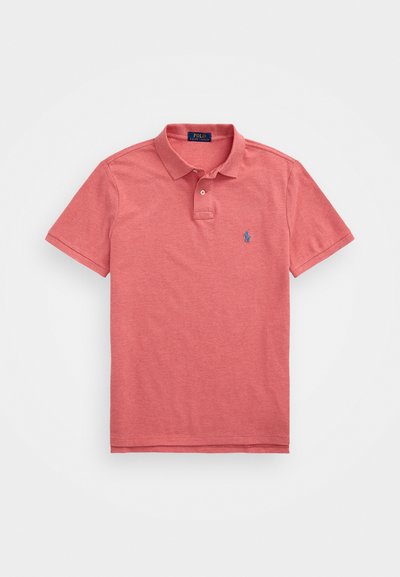 Κόκκινο πόλο μπλουζάκι φτιαγμένο από μαλακό βαμβάκι, με πλεκτό γιακά, δύο κουμπιά, κοντά μανίκια και μικρό μπλε λογότυπο στο αριστερό στήθος.