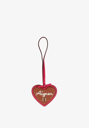 Portachiavi a forma di cuore in pelle marrone con rifinitura rosa, scritta "Aigner" in caratteri bianchi, emblema a ferro di cavallo argentato e un anello rosa per appenderlo.