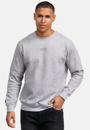 Sudadera gris claro en un tejido suave y texturizado. Cuenta con un escote redondo y puños ligeramente acanalados. Exhibida con un logo en el pecho.