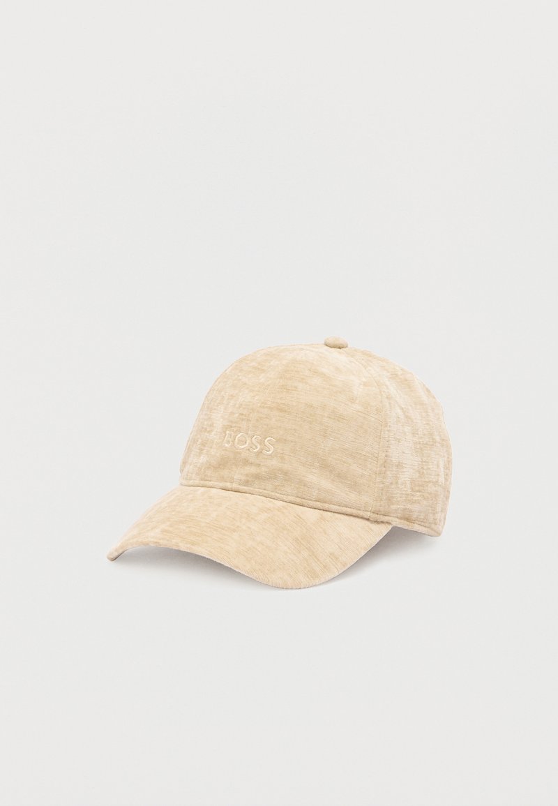 Gorra beige con visera curva, hecha de tela suave. Presenta el logo bordado "BOSS" en el frente. Superficie texturizada con un brillo sutil.