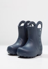 Stivaletti impermeabili blu navy in materiale resistente, con una finitura testurizzata, punta rotonda e pratiche maniglie per indossarli facilmente.