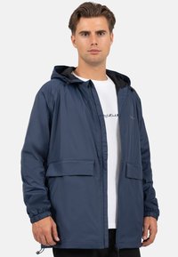 Navyblauwe lichtgewicht jas met een capuchon, elastische manchetten, twee voorkeurszakken en een volledige ritssluiting; gladde textuur en casual ontwerp.