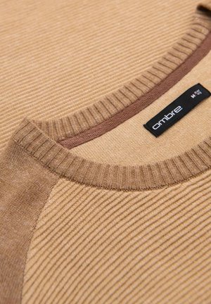 Maglione rigato marrone chiaro con scollatura rotonda e un elegante dettaglio marrone sul colletto. Etichetta del marchio visibile di lato.