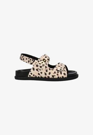 Open-toe sandaal met zwart-beige gevlekt patroon, twee verstelbare riemen met goudkleurige gesp, en een zwarte platte zool.