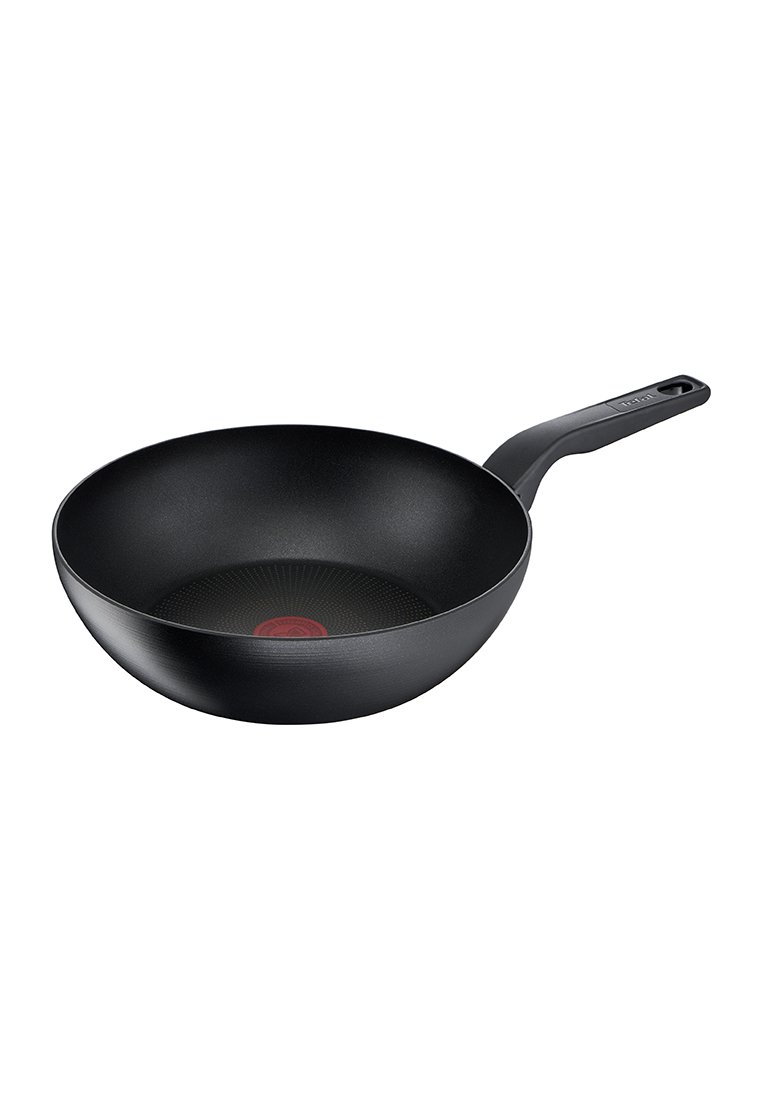 Wok nero antiaderente con forma arrotondata e interno testurizzato. Dotato di un manico nero robusto con un foro per appenderlo. Indicatore centrale rosso.