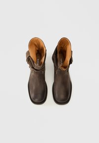 Bruna läderankelboots med en lätt slitna finish, med en brunt inre, stickade detaljer och en sidabälte.