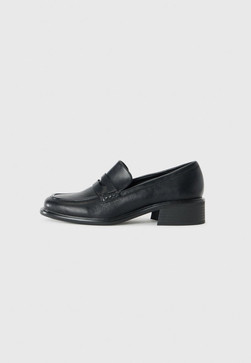 Black leather loafers with a low block heel, featuring a moccasin-style toe and decorative stitching across the instep.