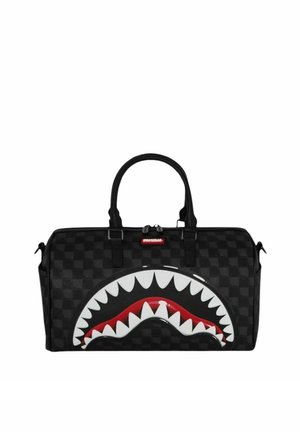 Bolsa de lona negra a cuadros con un gran diseño de boca de tiburón con dientes blancos y un interior rojo en el lado delantero, y dos asas superiores.