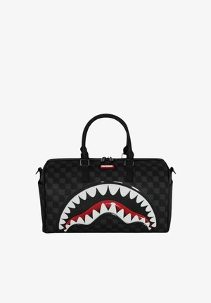 Bolsa de lona negra a cuadros con un gran diseño de boca de tiburón con dientes blancos y un interior rojo en el lado delantero, y dos asas superiores.
