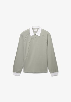 Polo shirt verde chiaro a maniche lunghe con colletto bianco, patta con tre bottoni e dettagli a cucitura curva sulla parte anteriore e sulle maniche.