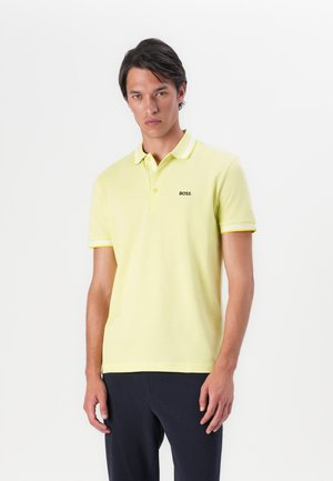 Polo jaune en coton, arborant un logo noir "BOSS", avec un col et des bords de manches contrastants, et une coupe classique.