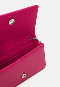 Rectangular pink wallet with a smooth, glossy texture. Features a snap closure, multiple card slots, and a silver hardware accent.