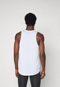 White athletic tank top made of smooth, lightweight fabric with a rounded neckline and slightly elongated back hem.