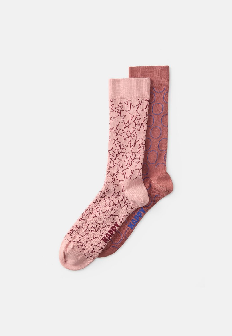 Calcetines rosas con un patrón de estrellas en la izquierda y un color sólido con acentos circulares en la derecha, ambos con puños acanalados y una marca de contraste.